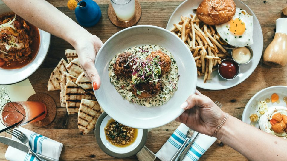 person holding white plate with food